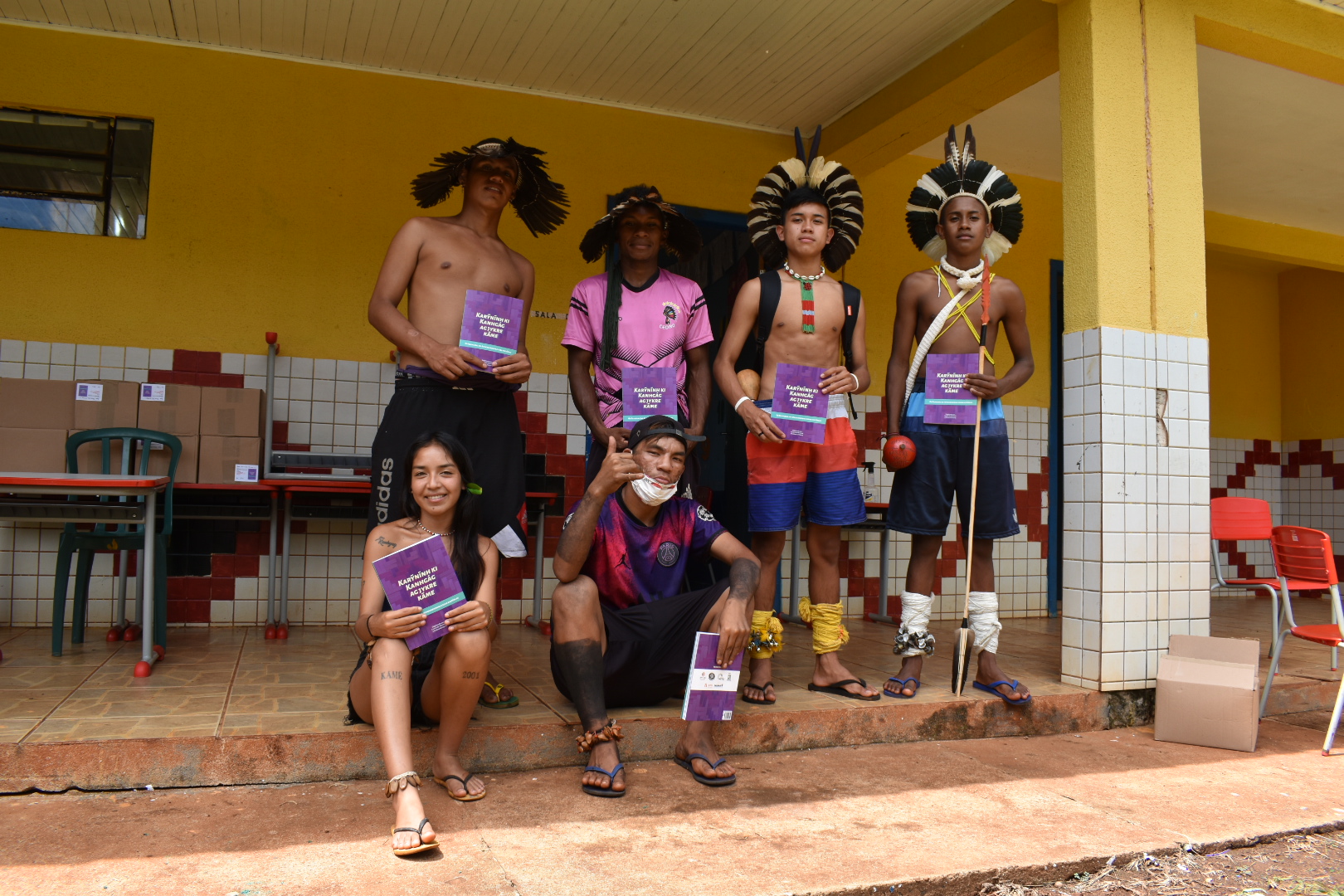 Jovens Kaingang mostram o livro publicado com histórias da comunidade